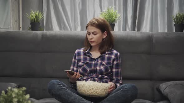 Young Adult Woman Watching Tv, Speaking on Smartphone