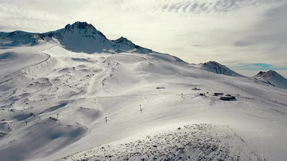 Aerial View Snow Mountain Peak Clouds in Background  Winter Drone Footage Ski Resort alt