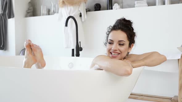 Happy and Smiling Woman Lying in The Tub