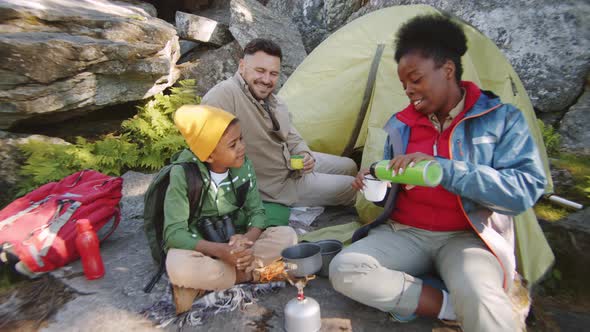 Happy Diverse Family Having Tea at Campsite alt