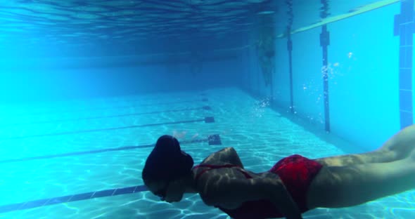 Slow motion of female swimmer diving in swimming pool alt