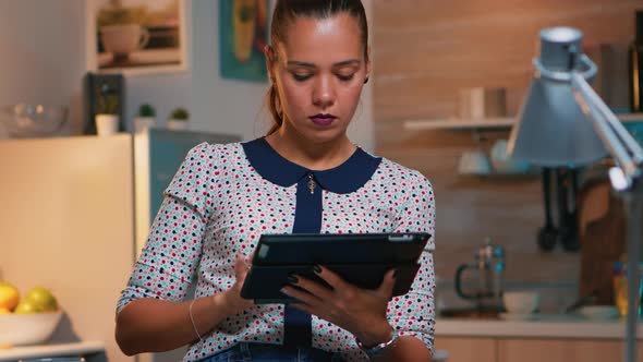 Businesswoman Taking Break Using Digital Tablet Late at Night alt