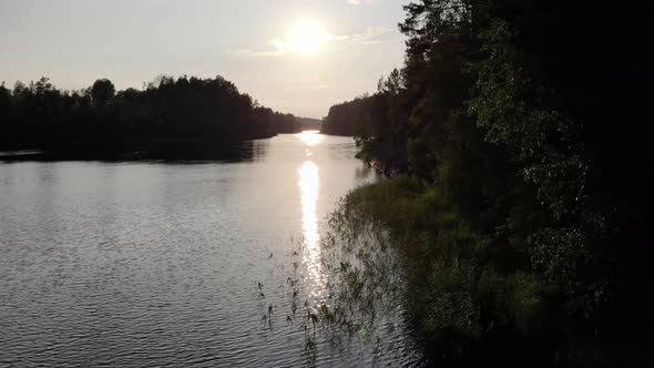 Bright evening sun shine ahead, reflection on ripply water