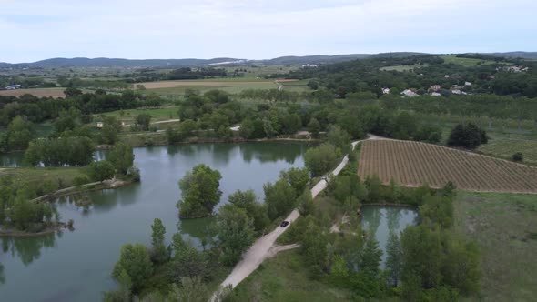 Aerial View of a Car Driving Close to a Lake in the South of France