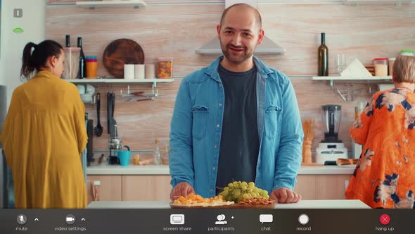 Husband Chatting in the Kitchen While His Family Prepares the Dinner alt