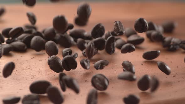 Coffee beans falling onto wooden surface in super slow motion.  Shot on Phantom Flex 4K high speed c