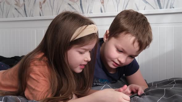 Little Boy and Girl Friends Playing Games on Smartphone Having Fun