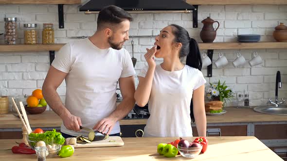 Man preparing salad dish. Girfriend having fun