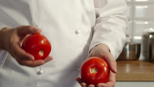 Chief-Cooker Juggles A Red Tomatoes In A Kitchen