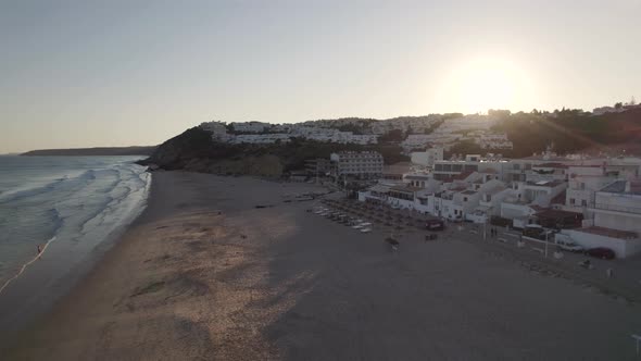 Sunset by the beach, Salema, Algarve. Sun kissed waves washing on the sand. Arerial view alt