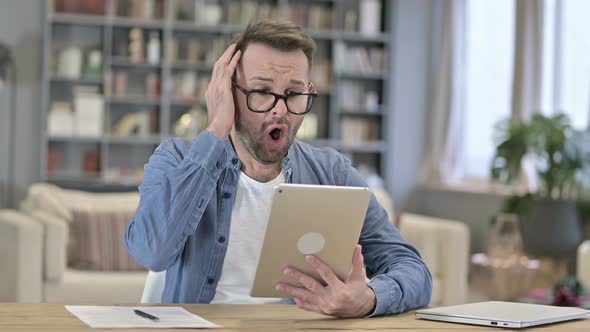 Upset Young Designer Reacting To Loss on Tablet in Loft Office alt