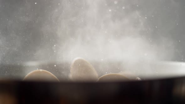 Camera follows cooking clams in a pan. Slow Motion. alt