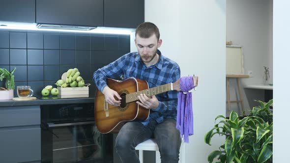 Man learning to play chords on acoustic guitar. Music concept alt