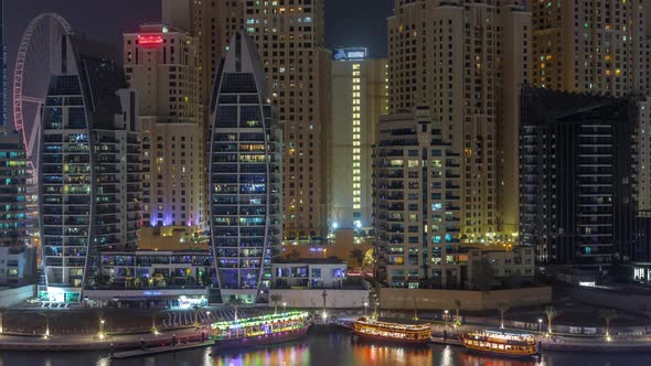 Luxury Yachts Parked on the Pier in Dubai Marina Bay with City Aerial View Night Timelapse alt