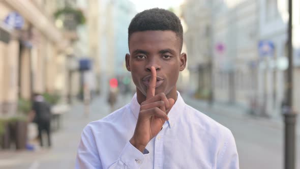 African Man Showing Quiet Sign By Finger on Lips alt