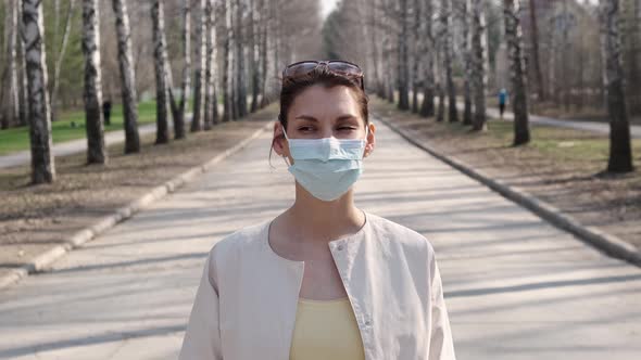 Young Girl in Medical Mask, Being Outdoors During Quarantine During Pandemic Covid-19, Looking at alt