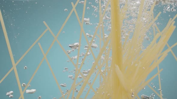 Spaghetti Throwing Into the Water on Blue Background Pasta Falling Into Water alt