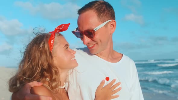 Positive Caucasian Couple Man and Woman Hugging Walking on Ocean Beach alt