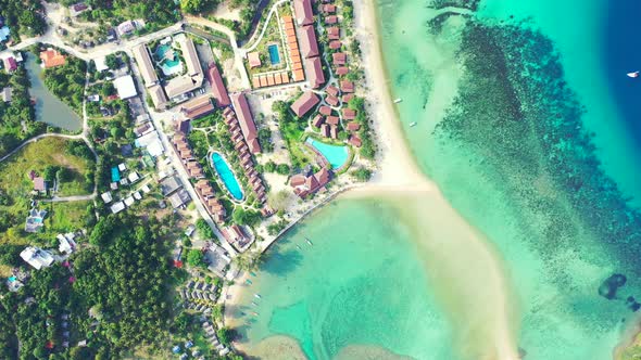 Thailand, aerial - luxury hotels and saltwater pools on the beachfront of the tropical island. alt