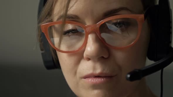 Closeup Portrait of Beautiful Serious Woman with Headphones and Microphone in Glasses Reflecting