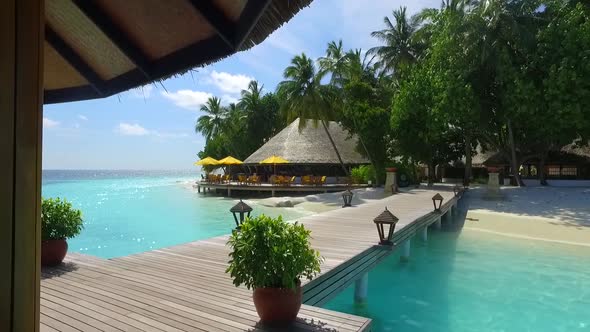 View of a tropical island dock pier over a beach. alt
