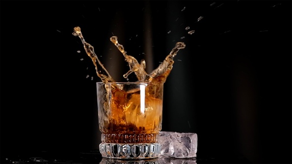 Ice Falling Into Whiskey Glass In Slow Motion