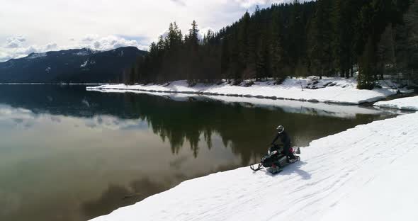 Snowmobile Driving Next To Lake Shore Cloudy Reflection Background Winter Extreme Motorsports alt