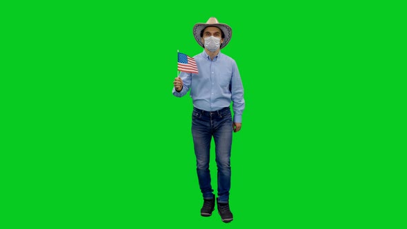 Walking Man in Mask and Cowboy Hat Holding Waving Flag of USA on Green Screen