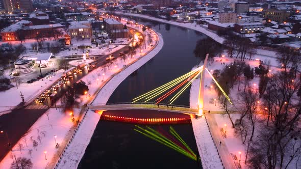 Illuminated bridge on winter river in Kharkiv city