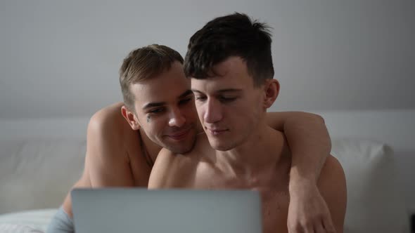 Portrait of Busy Young Gay Man Messaging Online on Laptop As Cheerful Boyfriend Covering Eyes with alt