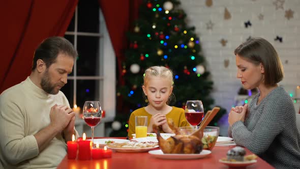 Traditional Family Praying Before Having Xmas Dinner, Belief in God Christianity alt