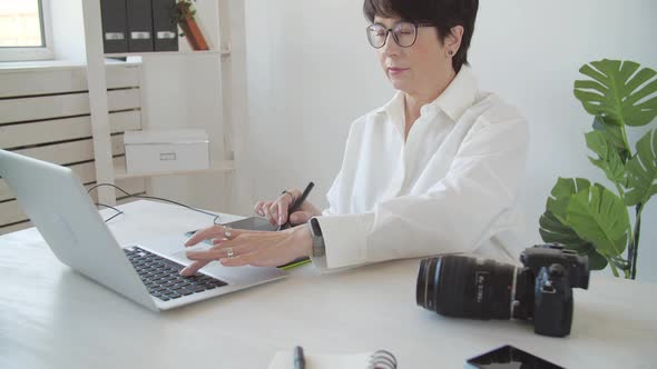 Creative Work and Hobby Concept Middleaged Woman Photo Editor Working on Computer at Her Desk with alt