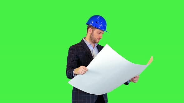 Successful Young Architect in Construction Helmet and Suit Analyzing Blueprint Supervising Building