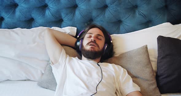 Male in Headphones Lying and Relaxing