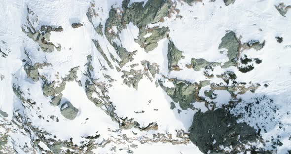 Overhead Aerial Top View Over Winter Snowy Mountain Rocks