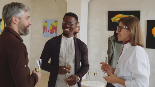 Cheerful Guests Chatting at Exhibition Opening Party in Art Gallery alt