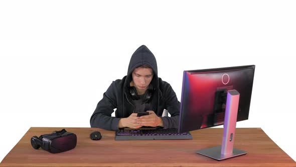 Hooded Hacker Using Laptop and Smartphone on White Background