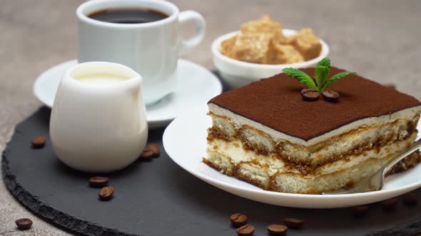 Portion of Traditional Italian Tiramisu dessert, cup of espresso and cream or milk alt