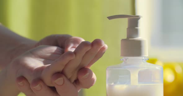 Mom treats her baby's hands with an antiseptic or liquid soap