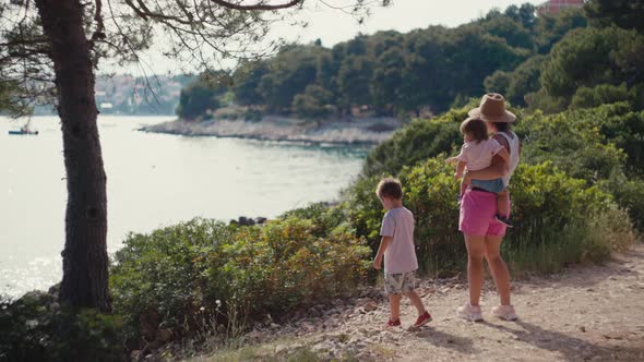 Slow Motion Video of a Family Walking Happy in the Summer By the Sea alt