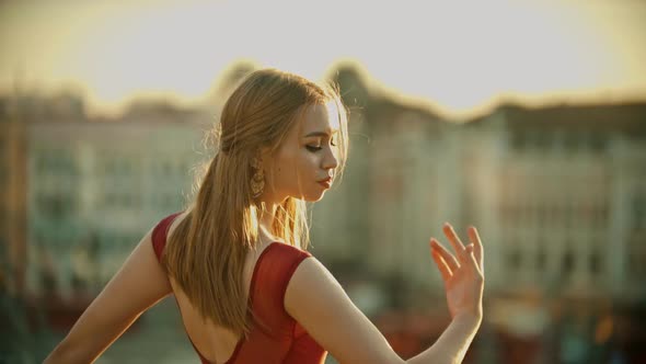 Young Graceful Smiling Woman Ballerina Training Her Dancing on the Roof on Sunset alt