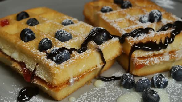 Pour Chocolate Topping Over Belgian Waffles with Berries and Condensed Milk alt
