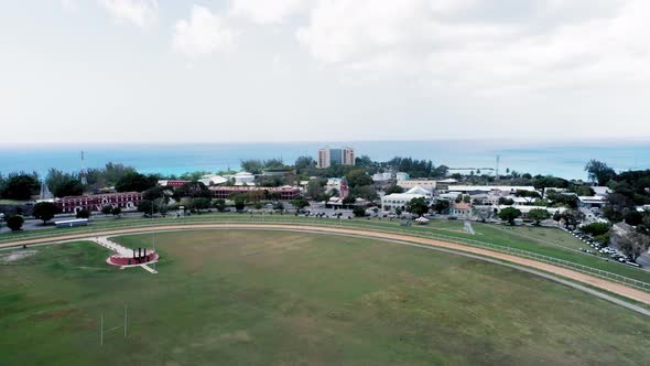 Aerial camera lifts over Garrison Savannah racecourse in Bridgetown, Barbados alt