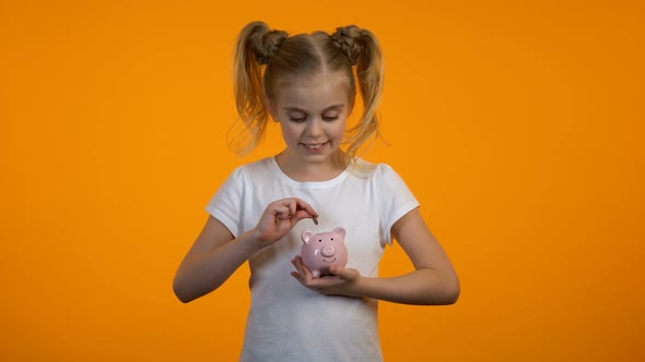 Smart Girl Putting Coin in Piggybank, Savings for Education, Banking for Juniors alt