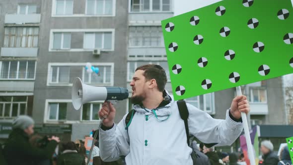 Emotional Talking Protester Speaking with Megaphone at Rally with Mockup Sign alt