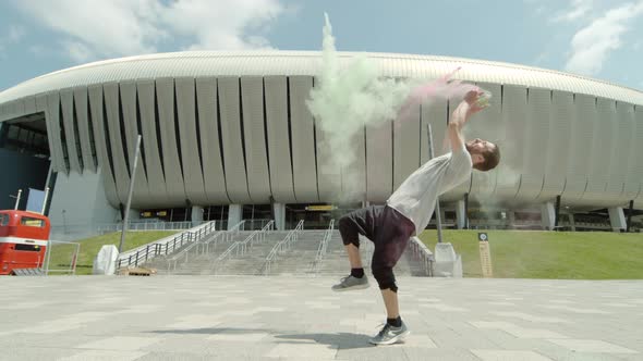 Man doing a back flip and throwing colorful powder, Ultra Slow Motion alt