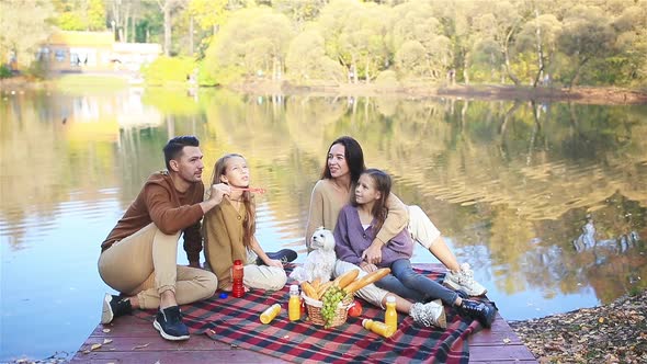 Happy Family on a Picnic in the Park at Autumn