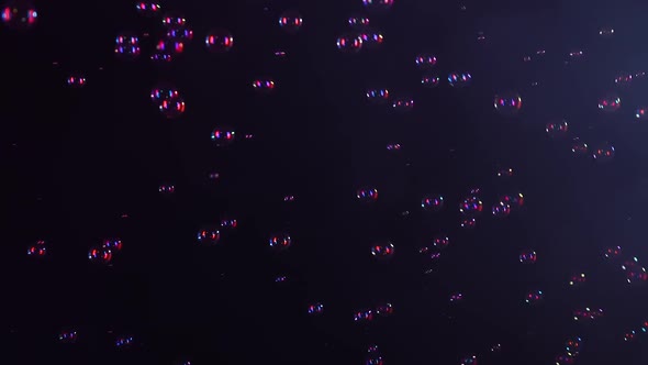 Beautiful Soap Bubbles Fly in a Smoky Studio on a Black Background in Red Neon Light alt