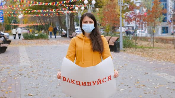 A Woman Raises a Poster with a Text in Ukrainian Translated From Ukrainian Vaccinated alt