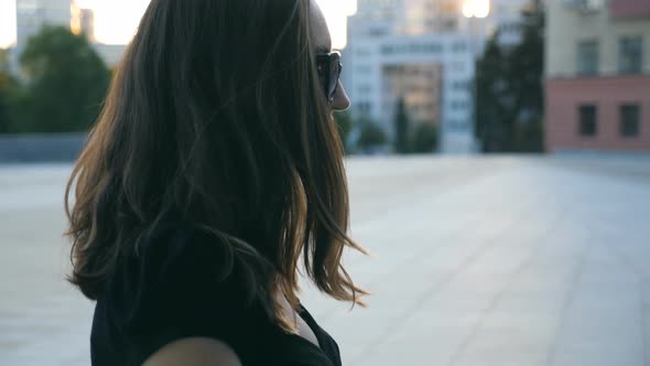 Young Business Woman in Sunglasses Walking on the Stairs in City Street. Attractive Businesswoman alt